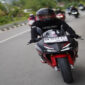 Pengendara saat mengendarai sepeda motor Honda di jalan raya. 