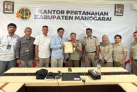 Pihak BPN dan PLN saat menyerahkan sertifikat tanah.
