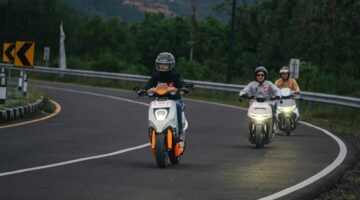 Terlihat tida pengendara saat mengendarai sepeda motor listrik Honda.