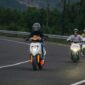 Terlihat tida pengendara saat mengendarai sepeda motor listrik Honda.