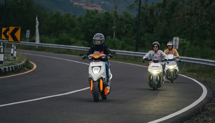 Terlihat tida pengendara saat mengendarai sepeda motor listrik Honda.