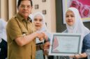 Bupati Lotim, H Haerul Warisin menyerahkan piagam penghargaan IBI kepada para juara Akseptor KB MKJP terbanyak pada HUT IBI tahun 2025.