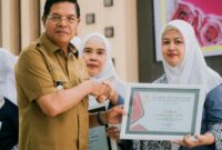 Bupati Lotim, H Haerul Warisin menyerahkan piagam penghargaan IBI kepada para juara Akseptor KB MKJP terbanyak pada HUT IBI tahun 2025.