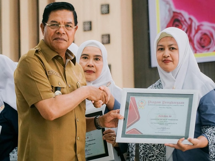 Bupati Lotim, H Haerul Warisin menyerahkan piagam penghargaan IBI kepada para juara Akseptor KB MKJP terbanyak pada HUT IBI tahun 2025.