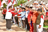 Gubernur NTB, Lalu Muhamad Iqbal saat membagikan Bendera Merah Putih.