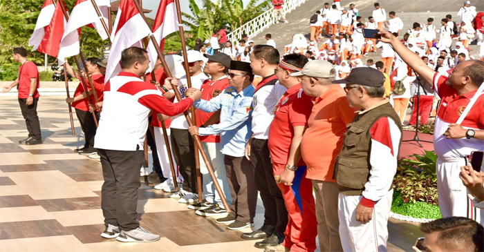 Gubernur NTB, Lalu Muhamad Iqbal saat membagikan Bendera Merah Putih.
