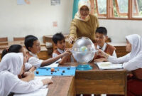 Terlihat ibu guru sedang fokus mengajar muridnya di  ruang kelas.