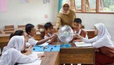 Terlihat ibu guru sedang fokus mengajar muridnya di  ruang kelas.