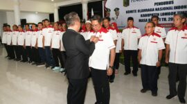 Ketua Umum KONI NTB, H Mori Hanafi saat memasang lencana kepada Bupati Lotim, H Haerul Warisin selaku Ketua KONI Lotim, Ahad (16/11/2025).