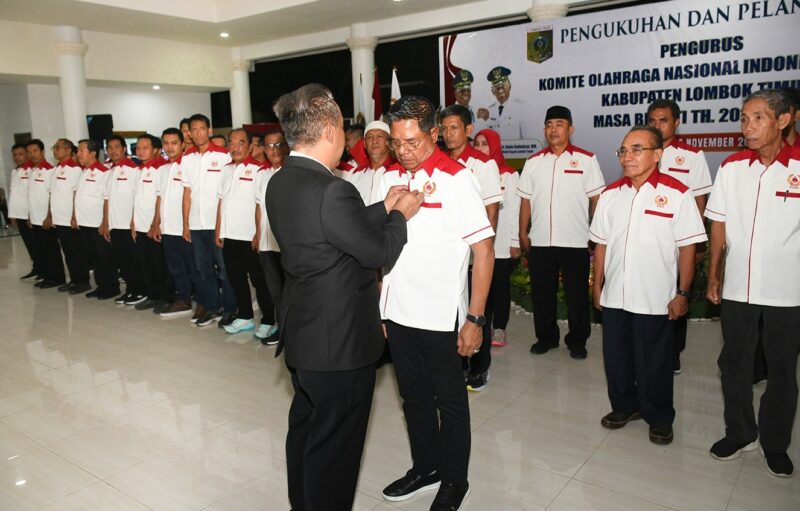 Ketua Umum KONI NTB, H Mori Hanafi saat memasang lencana kepada Bupati Lotim, H Haerul Warisin selaku Ketua KONI Lotim, Ahad (16/11/2025).