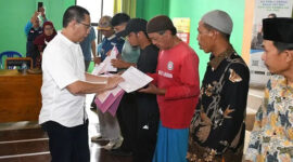 Wabup Lotim, HM Edwin Hadiwijaya Saat menyerahkan tanda kepesertaan Jamsostek.