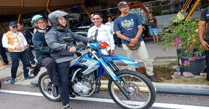 Gubernur NTB, Lalu Muhamad Iqbal berboncengan sama istri, Sinta Agathia Iqbal menggunakan motor trail untuk menyusuri jalan yang rusak di Sumbawa.