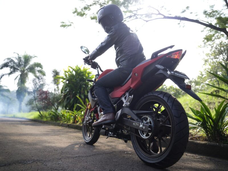 Salah seorang pengendara sepeda motor Honda saat mengecek atau melihat ke belakang terlebih dahulu sebelum melaju kencang motornya.
