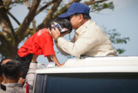 Presiden Prabowo Subianto mencium kening bocah dari atas mobilnya di sela-sela menyapa warga Lombok Barat saat menuju Bendungan Meninting di Kabupaten Lombok Barat, Jumat (10/7/2026). 