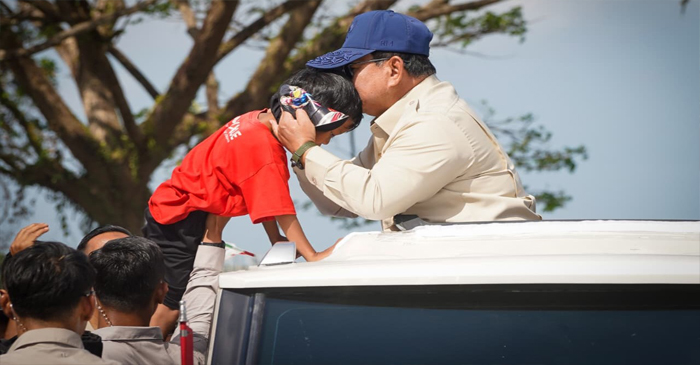 Presiden Prabowo Subianto mencium kening bocah dari atas mobilnya di sela-sela menyapa warga Lombok Barat saat menuju Bendungan Meninting di Kabupaten Lombok Barat, Jumat (10/7/2026). 